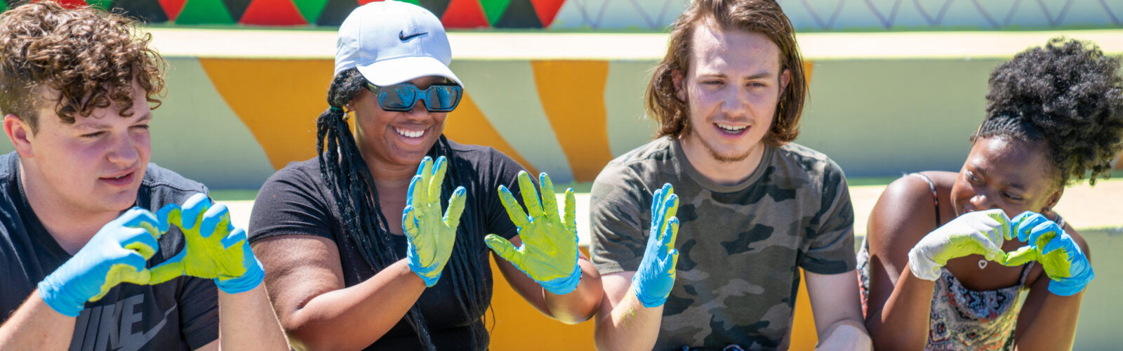 Community members show off their painted hands during a community painting day at the Black Lives Matter mural
