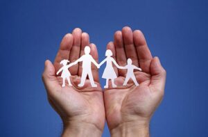 Cutout paper chain family with the protection of cupped hands, concept for security and care