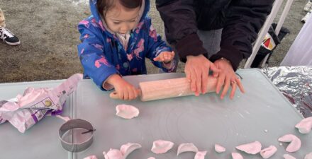 Child rolls out clay to create a ceramic dumpling.
