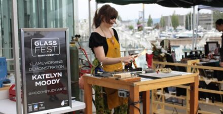 Artist demonstrating glass art using a torch outside the Musuem of Glass.