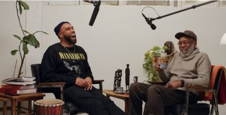 Two men laughing as they talk to each other during an interview.