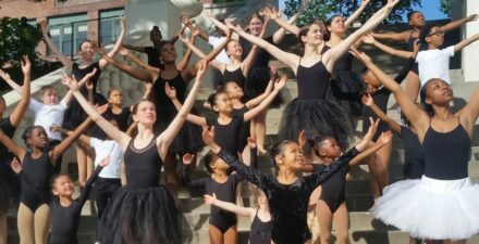 Youth ballet dancers from Tacoma Urban Performing Arts Center pose on a set of stone steps.