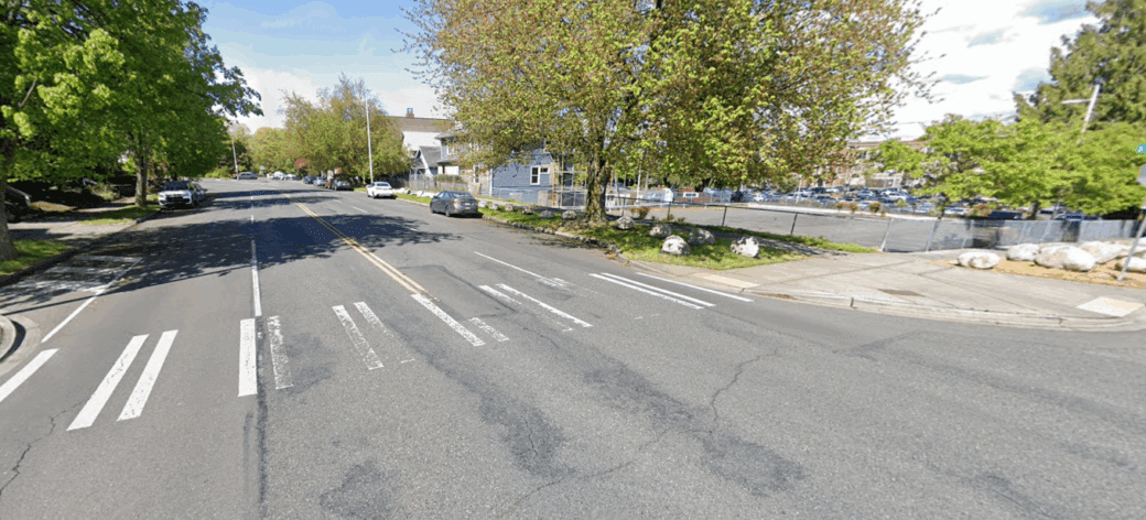 Street view photo taken on Yakima Avenue near the I Street Transition. Asphalt deterioration is visible.