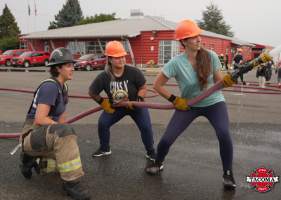 Women learning how to use a fire hose
